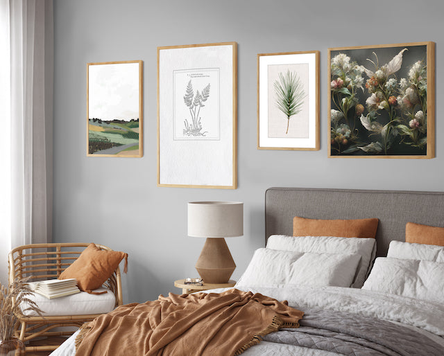 Earthy gallery wall with botanical wall art in green and earthy tones in a neutral and grey bedroom.