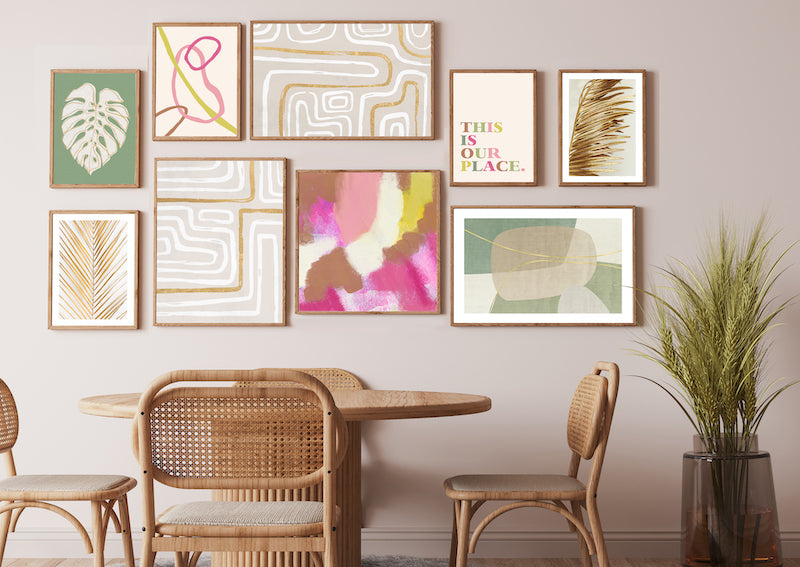 Colourful, pink, green, gold abstract wall art gallery wall pictured in a neutral dining room.