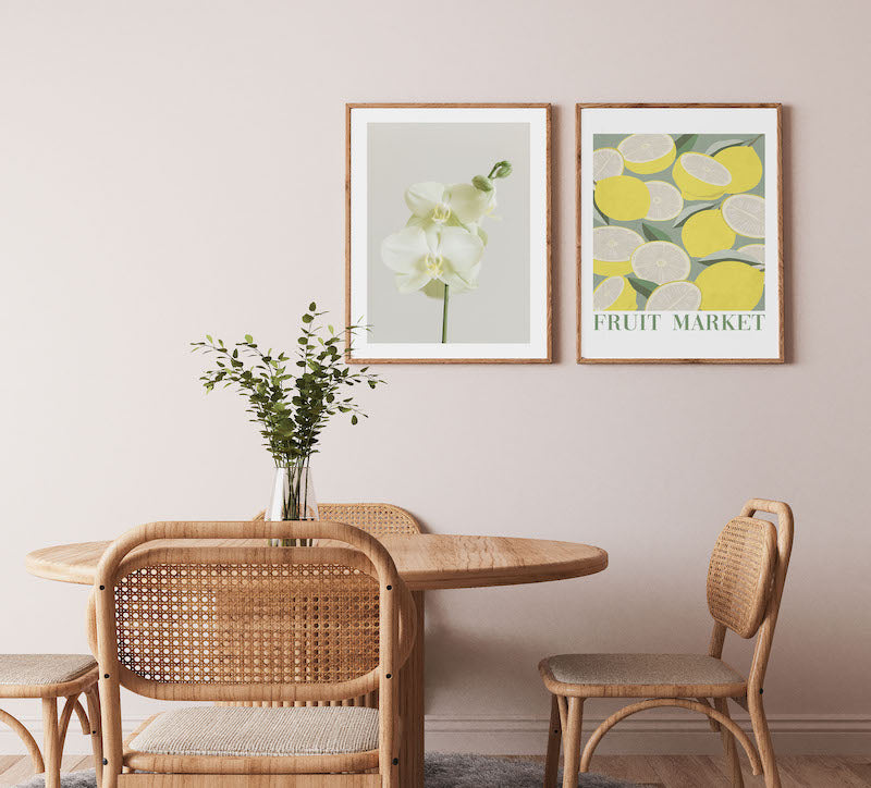Set of 2 botanical wall art of orchids and lemons in a wooden dining room.