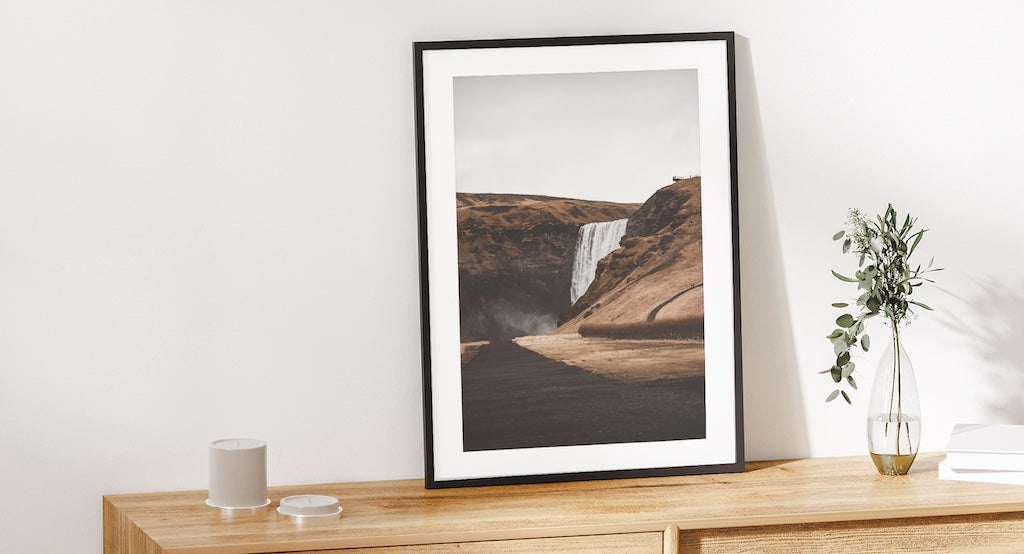 Waterfall landscape photography wall art in neutral living room.