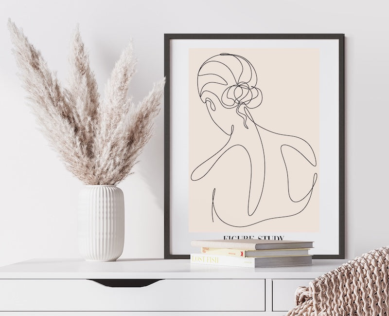 Abstract line drawing of a female figure framed in a black frame and pictured in a home office space. 