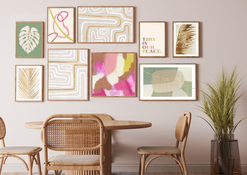 Colourful, pink, green, gold abstract wall art gallery wall pictured in a neutral dining room. 